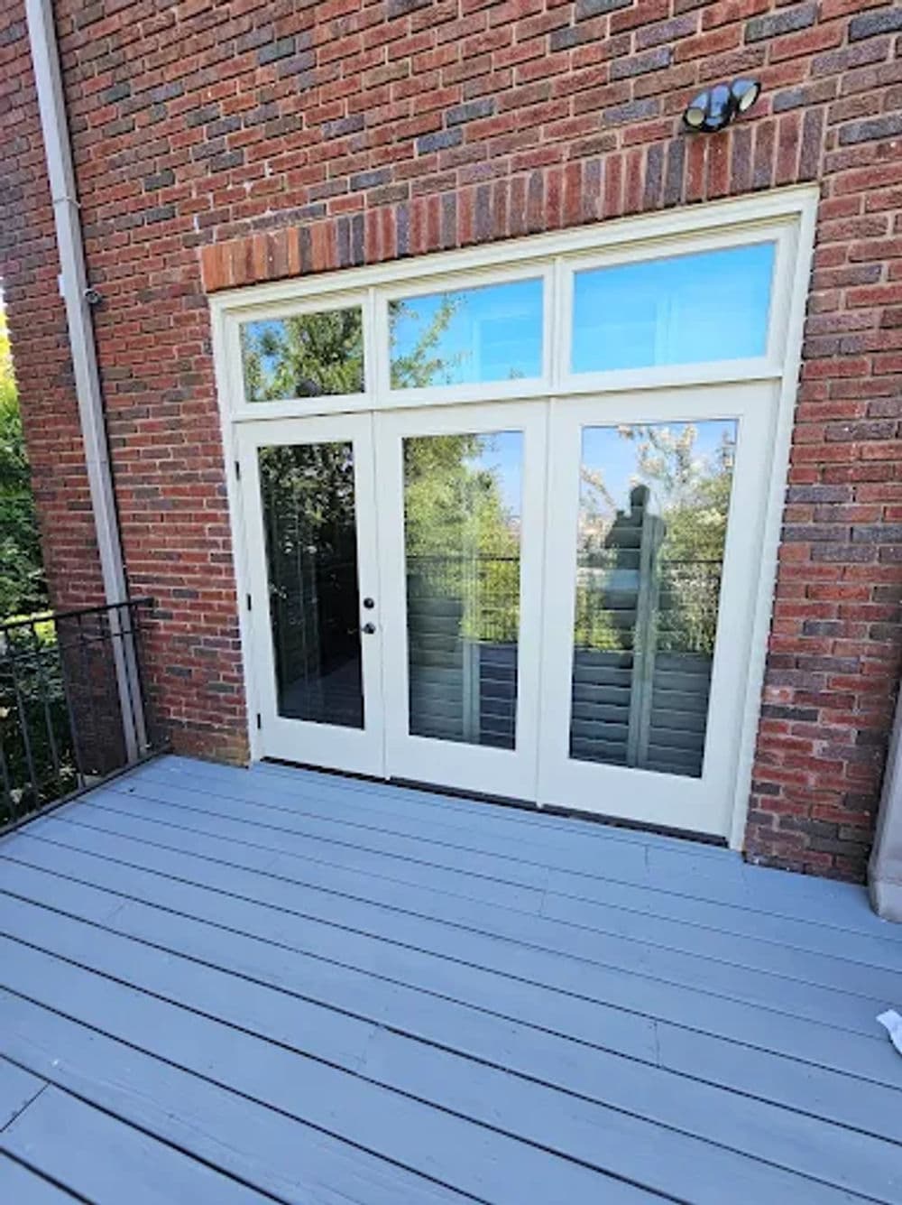 Elegant dual glass doors with a brick exterior, leading to a scenic outdoor view.