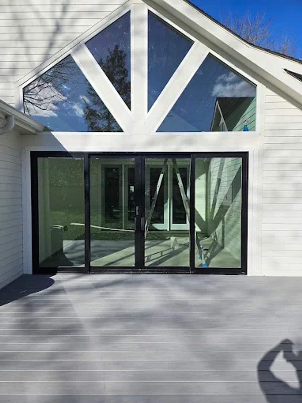 Modern glass doors with a triangular window design, showcasing sleek outdoor living space.