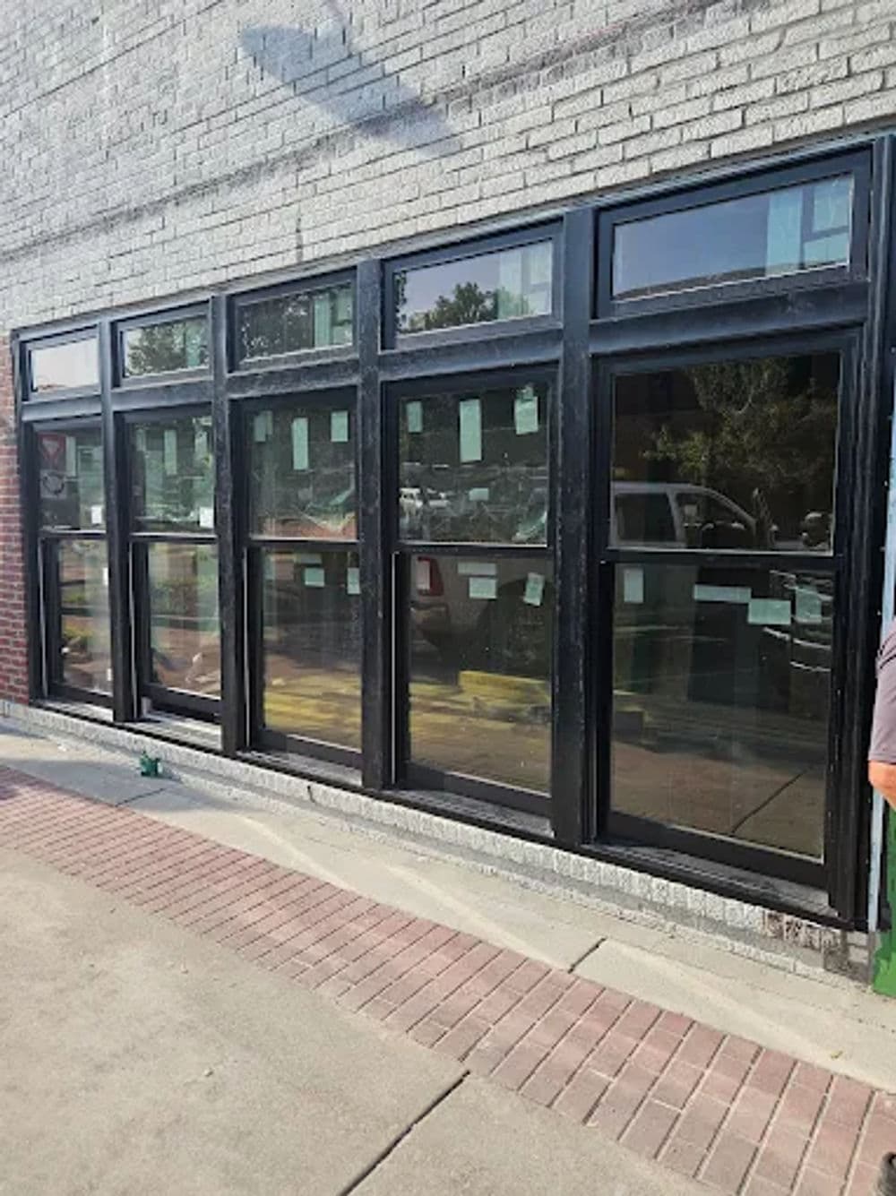 Modern black frame windows on a brick wall, showcasing urban architectural design elements.