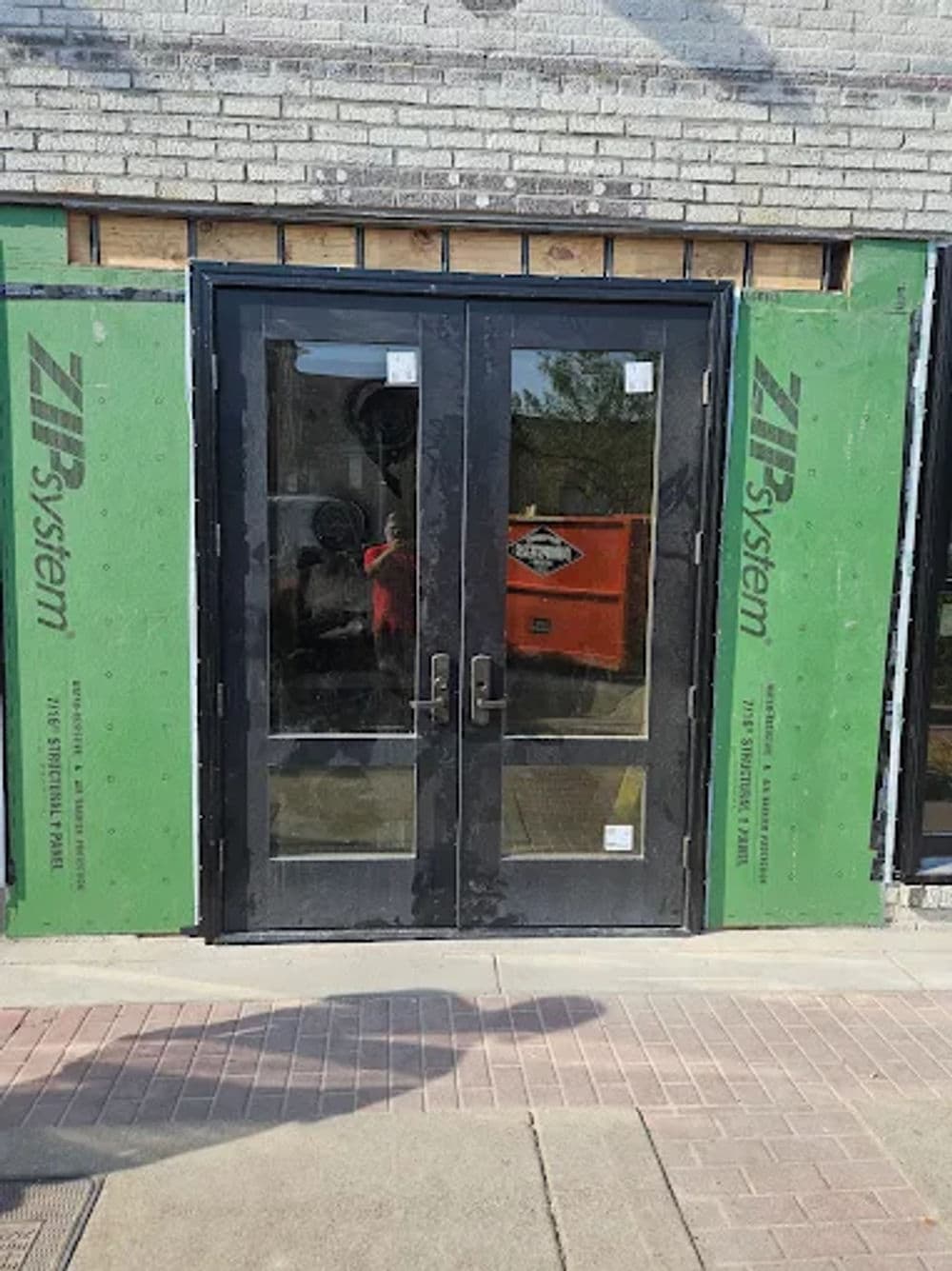 Newly installed double glass doors framed with ZIP System sheathing for weather protection.