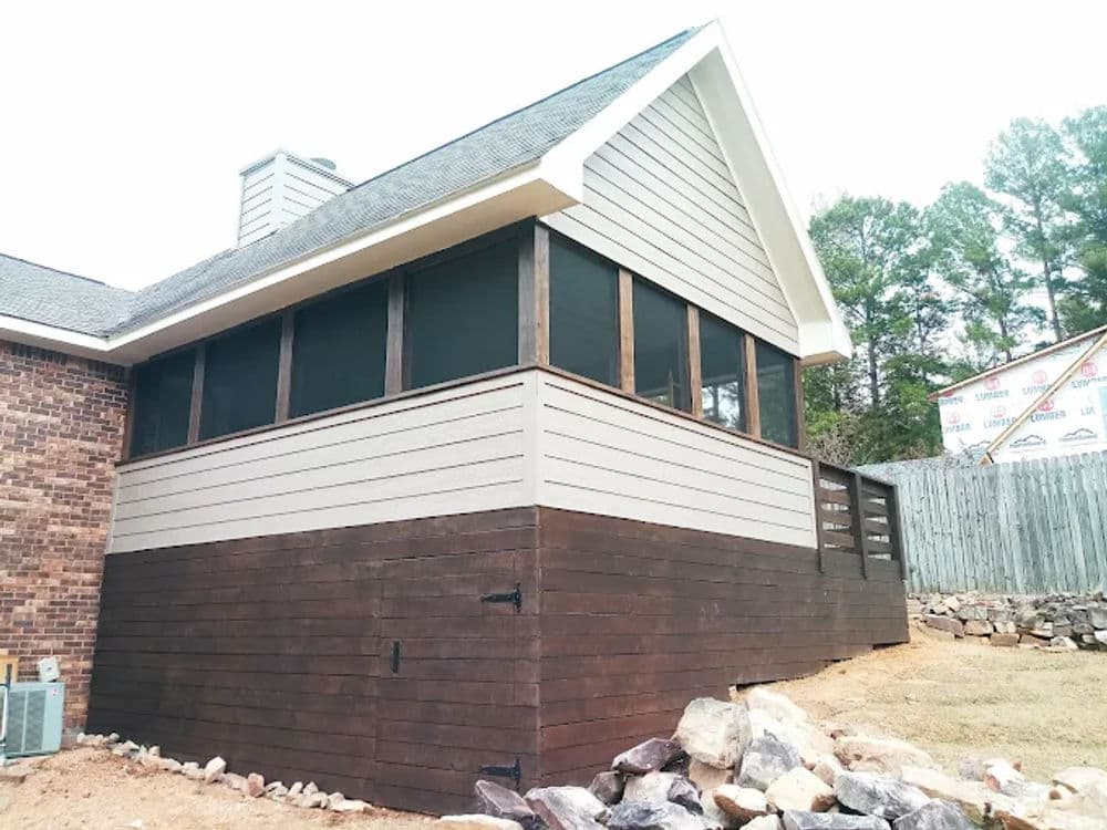 Newly built screened-in porch with wooden accents and stone landscaping.