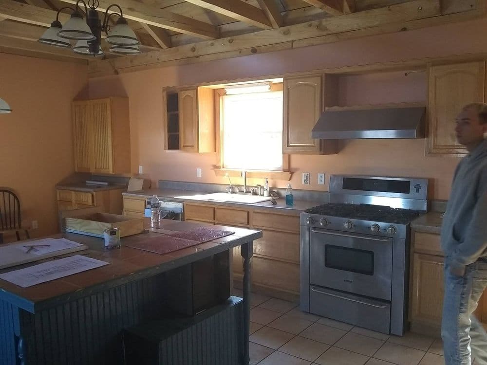 Modern kitchen with wooden cabinets, stainless steel appliances, and a large island.