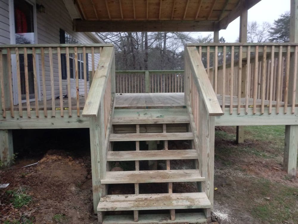 Newly built wooden deck with steps and railings, showcasing quality craftsmanship.
